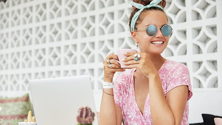 Mujer vestida con conceptos básicos de moda clave: gafas de sol, joyas y bufanda.