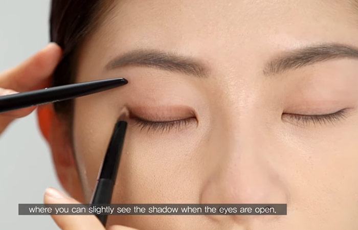 El paso 4 del maquillaje de ojos encapuchados es aplicar la sombra de ojos en el párpado superior del ojo encapuchado